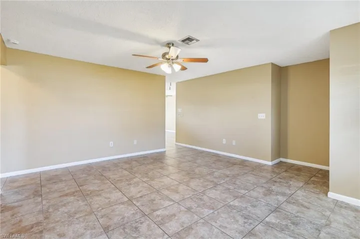 Unfurnished room featuring ceiling fan and light tile floors