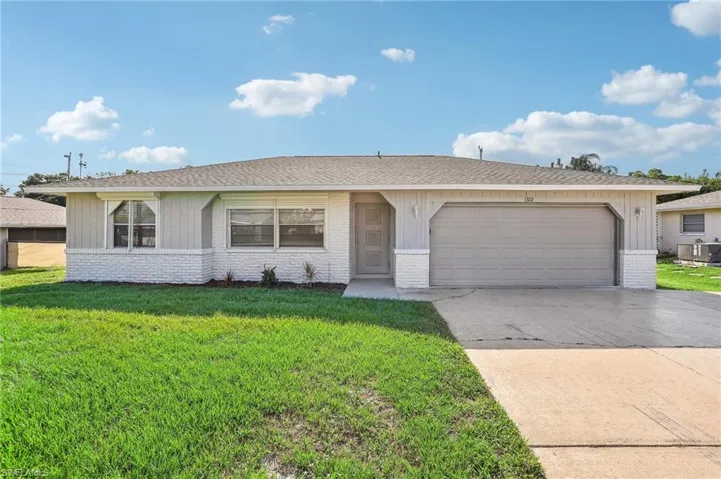 Ranch-style house featuring a garage, central AC, and a front lawn