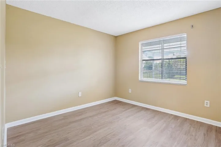 Unfurnished room featuring light hardwood / wood-style floors and a textured ceiling