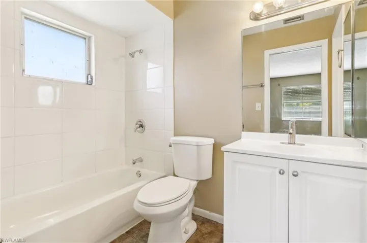 Full bathroom featuring tile floors, tiled shower / bath, vanity with extensive cabinet space, and toilet