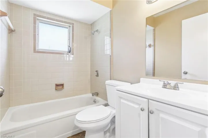 Full bathroom featuring tiled shower / bath, toilet, and vanity