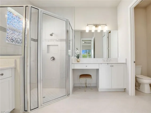 Bathroom with tile flooring, an enclosed shower, and vanity