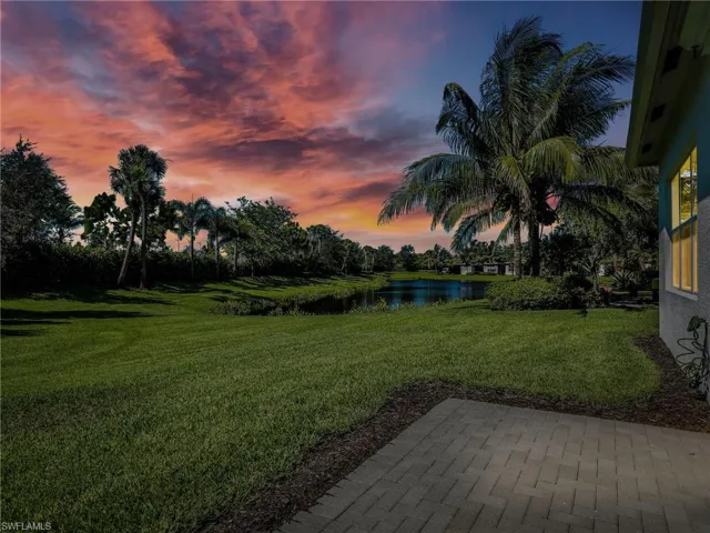 Yard at dusk with a patio area and a water view