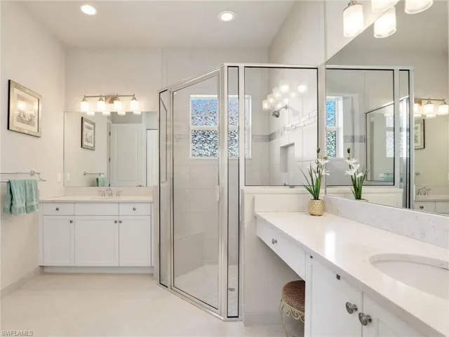 Bathroom featuring tile flooring, a shower with shower door, and oversized vanity