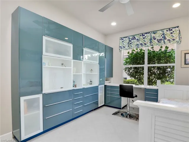 Tiled bedroom featuring built in desk and ceiling fan
