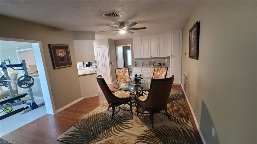 Dining space featuring light wood-style flooring, a textured ceiling, and ceiling fan