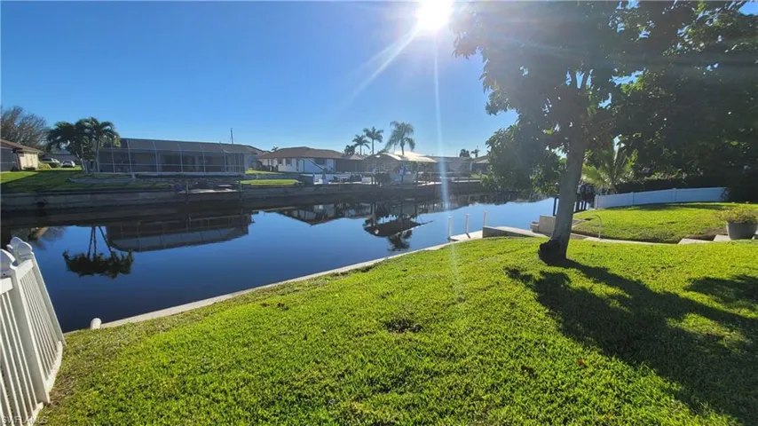 Water view featuring a boat dock and nearby suburban area