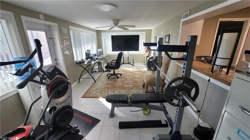 Workout room with light tile patterned floors and ceiling fan