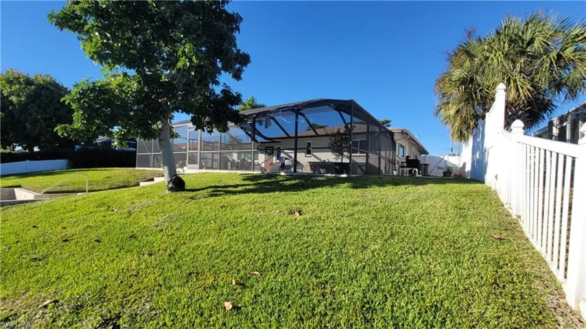 Fenced backyard featuring a sunroom and glass enclosure