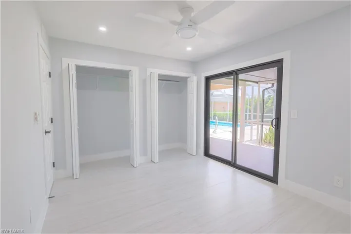 Unfurnished bedroom with ceiling fan and access to exterior