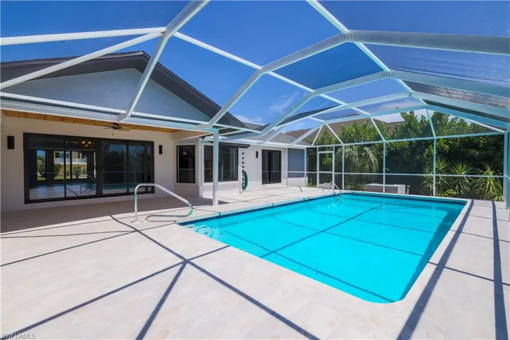 View of pool with a patio area and a lanai