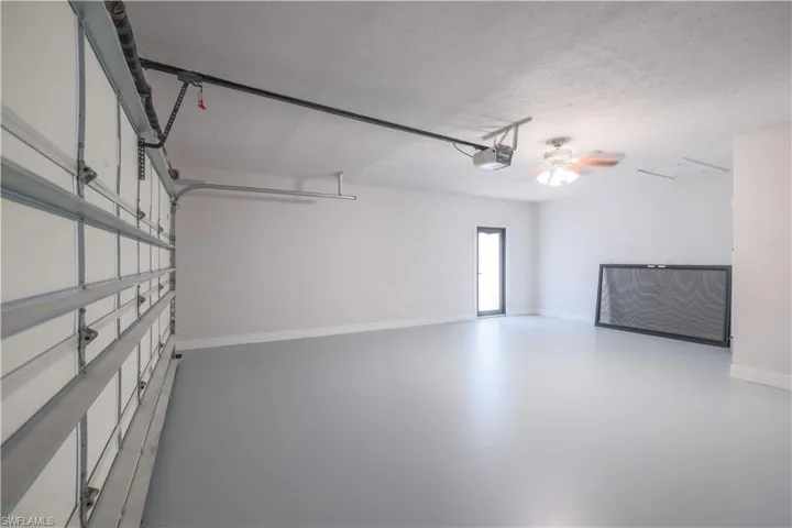 Garage featuring ceiling fan and a garage door opener