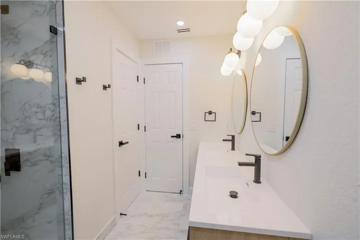 Bathroom with vanity, tile patterned floors, and a shower with shower door