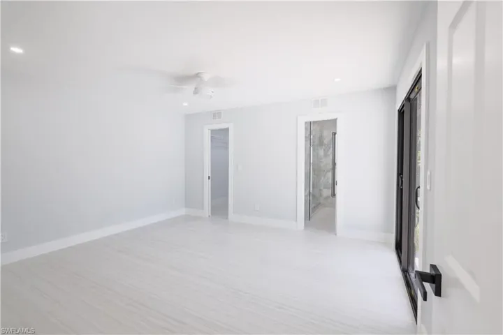 Unfurnished bedroom with a closet, ceiling fan, and connected bathroom