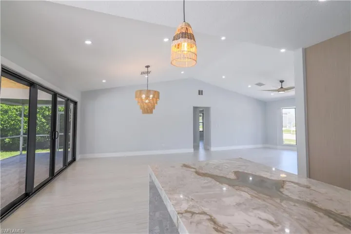 Unfurnished room featuring ceiling fan with notable chandelier