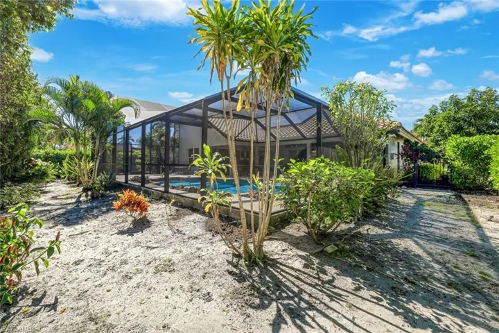 Back of property with glass enclosure, a sunroom, and an outdoor pool