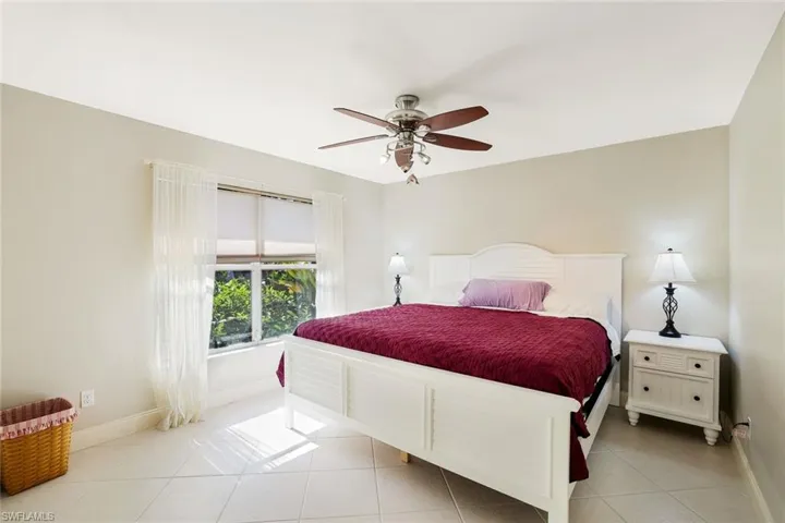 Bedroom with light tile patterned flooring and a ceiling fan