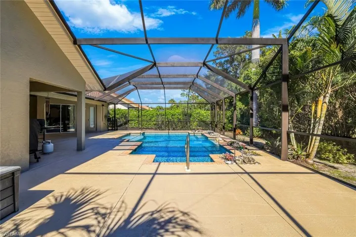 Outdoor pool with a patio area, a sunroom, and glass enclosure