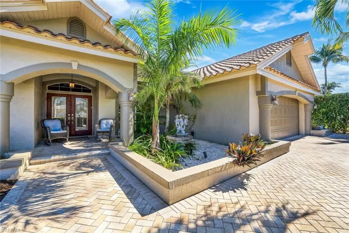 Entrance to property featuring french doors, a tiled roof, an attached garage, and stucco siding