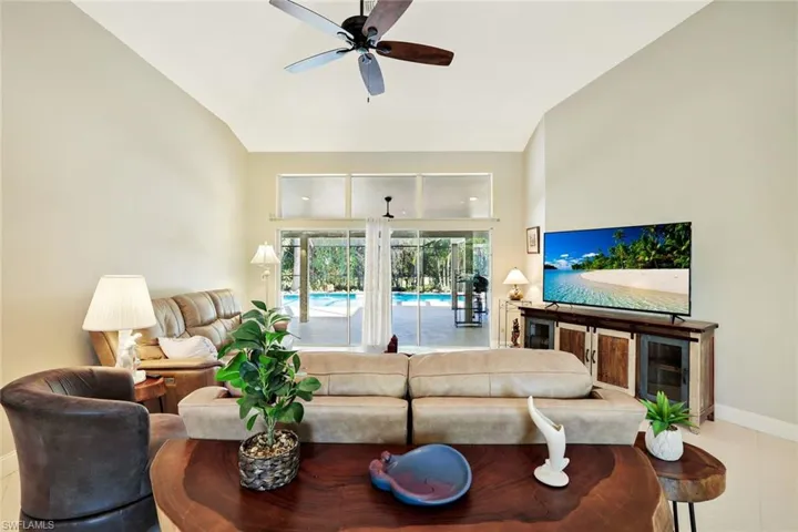 Living area featuring light tile patterned floors, a ceiling fan, and high vaulted ceiling