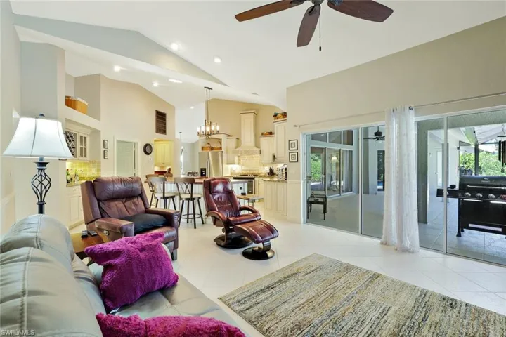 Living area featuring high vaulted ceiling, light tile patterned flooring, a ceiling fan, a sunroom, and recessed lighting