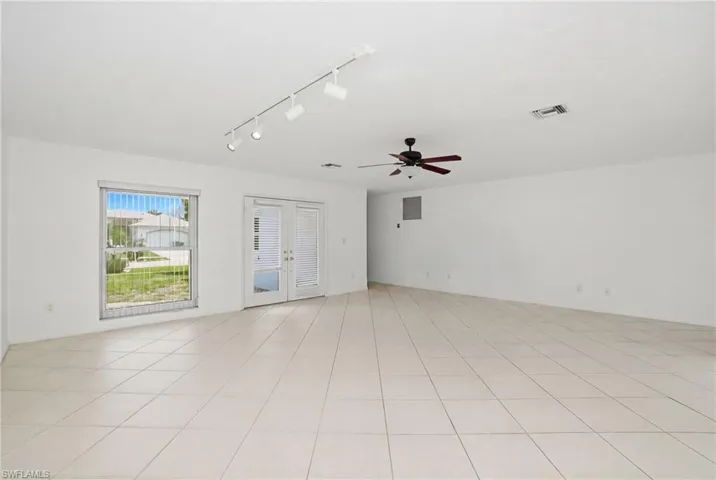 The expansive living area features light-colored tile flooring.