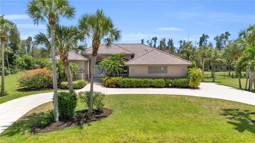 View of front facade featuring a front yard and a circular driveway
