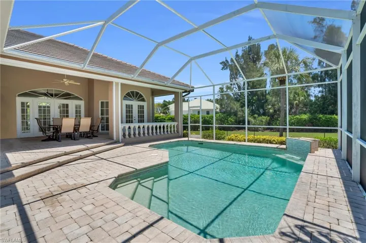 View of pool with ceiling fan, french doors, glass enclosure, and a patio area