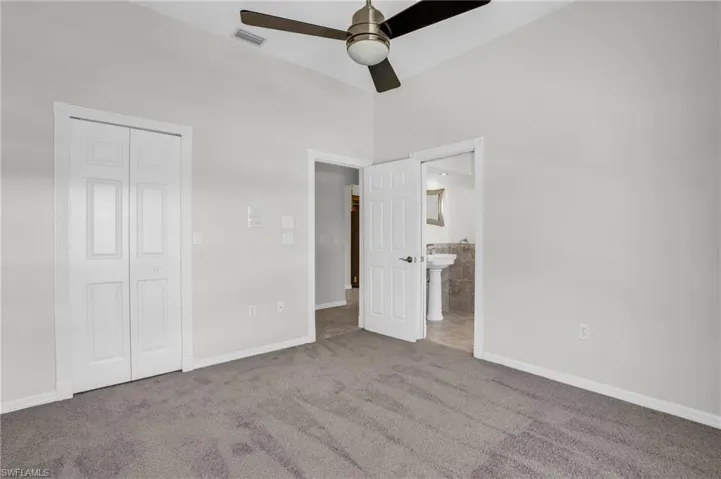 Unfurnished bedroom with high vaulted ceiling, ceiling fan, carpet floors, and a closet