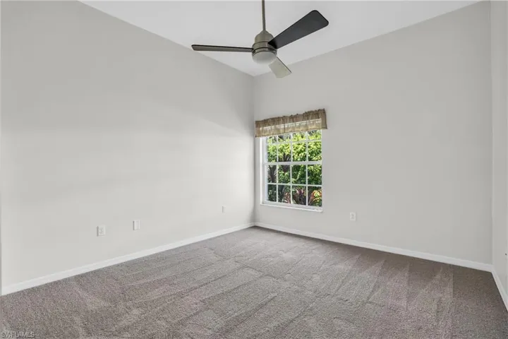 Carpeted empty room featuring ceiling fan