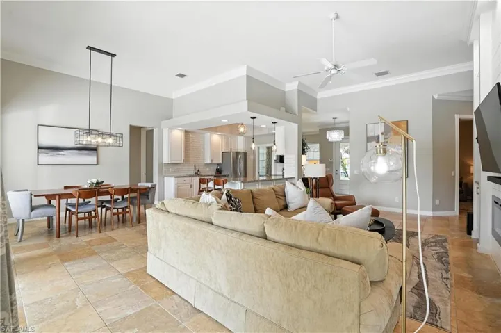 Living room featuring ornamental molding and ceiling fan