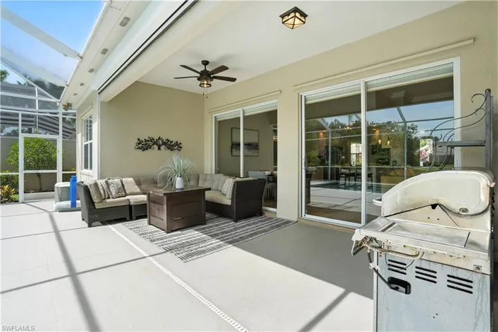 View of patio / terrace featuring an outdoor hangout area, a ceiling fan, grilling area, and glass enclosure
