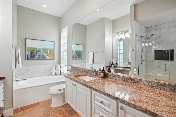 Full bath with vanity, a bath, and a stall shower