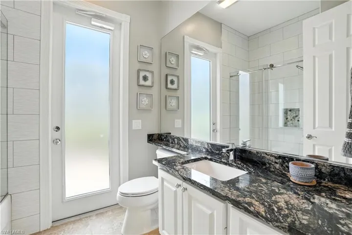 Bathroom with vanity, healthy amount of natural light, and tile patterned flooring