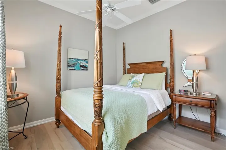 Bedroom with wood finished floors, ornamental molding, and ceiling fan
