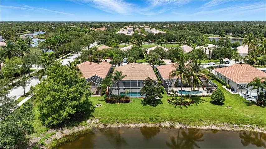 Aerial perspective of suburban area featuring a large body of water and a pool area