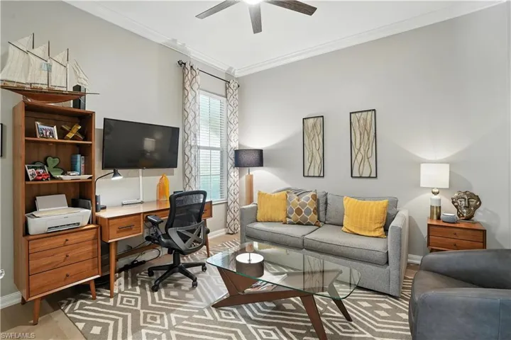 Office featuring crown molding, light wood-style flooring, and a ceiling fan