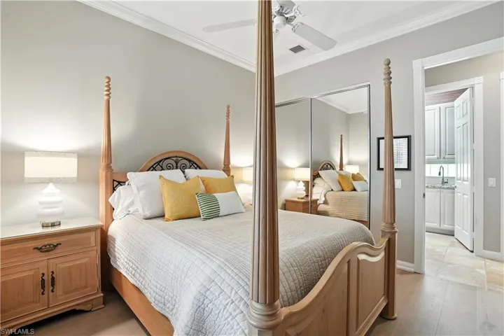 Bedroom featuring ornamental molding, a ceiling fan, ensuite bathroom, and a closet