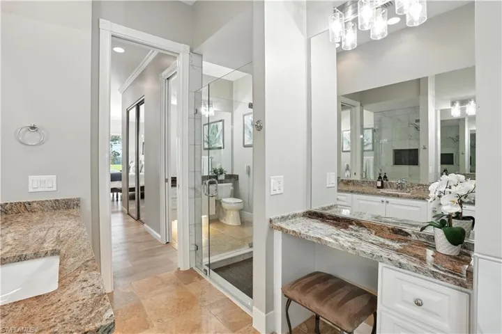 Bathroom with a shower stall, vanity, and a chandelier