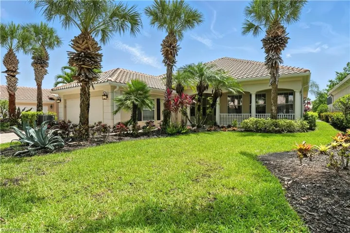 Mediterranean / spanish home with a garage, a front yard, a tiled roof, a porch, and stucco siding