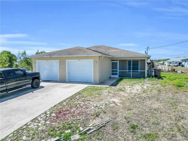 Stucco exterior featuring dual garage doors, a concrete driveway, a screened-in porch, and a shingle roof