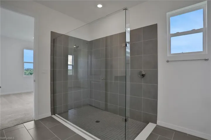 Bathroom featuring walk in shower, tile patterned flooring, and carpet flooring