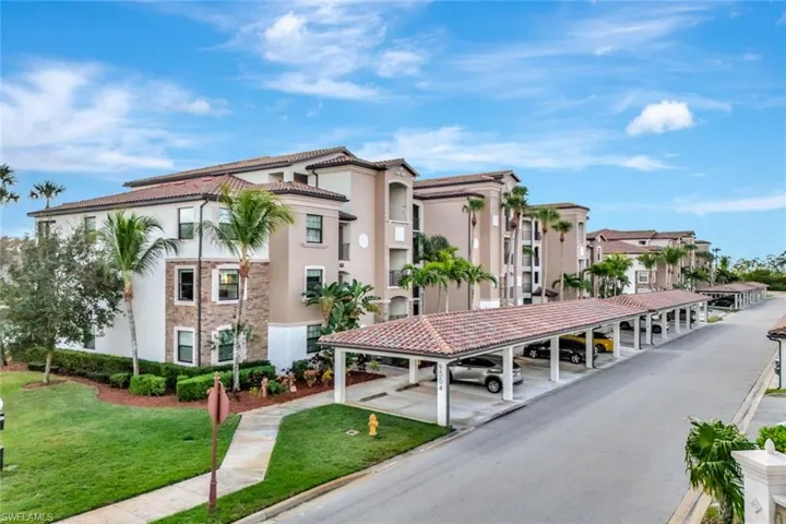 View of apartment building / complex with covered parking