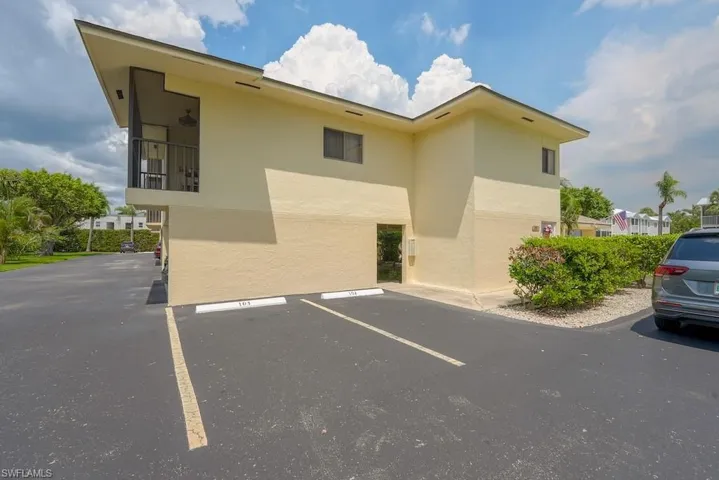 View of building exterior featuring uncovered parking