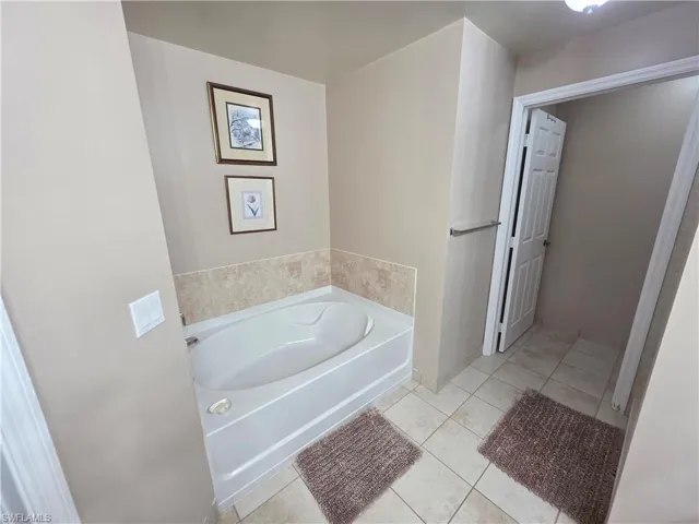 Bathroom featuring a bath and light tile patterned floors