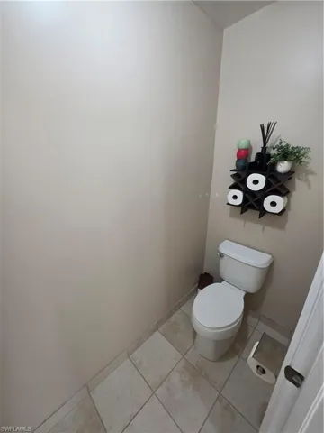 Bathroom with light tile patterned floors and toilet