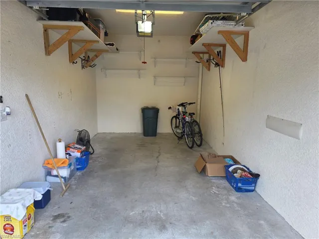 Garage featuring a textured wall and a garage door opener