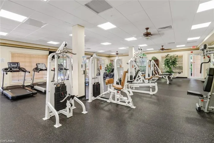 Exercise room featuring a drop ceiling and a ceiling fan