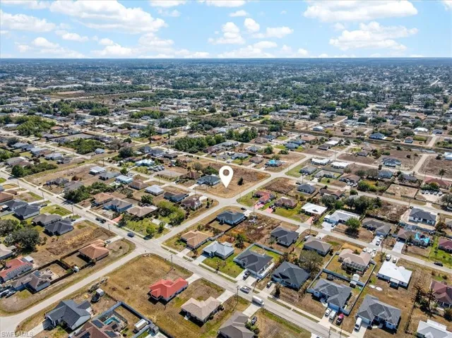 Aerial view of property and surrounding area featuring nearby suburban area