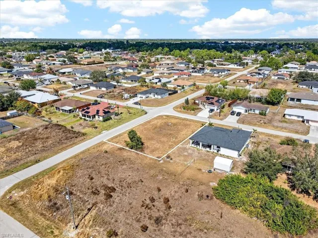 Aerial view of property and surrounding area featuring nearby suburban area